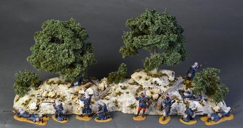 Felsige Landschaft mit Olivenbäumen und Sträuchern